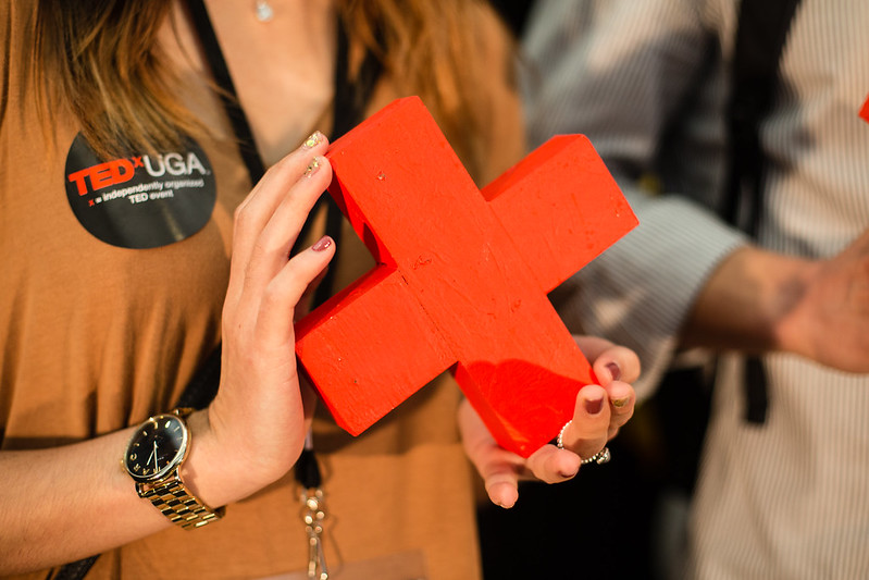 Hands holding a wooden X