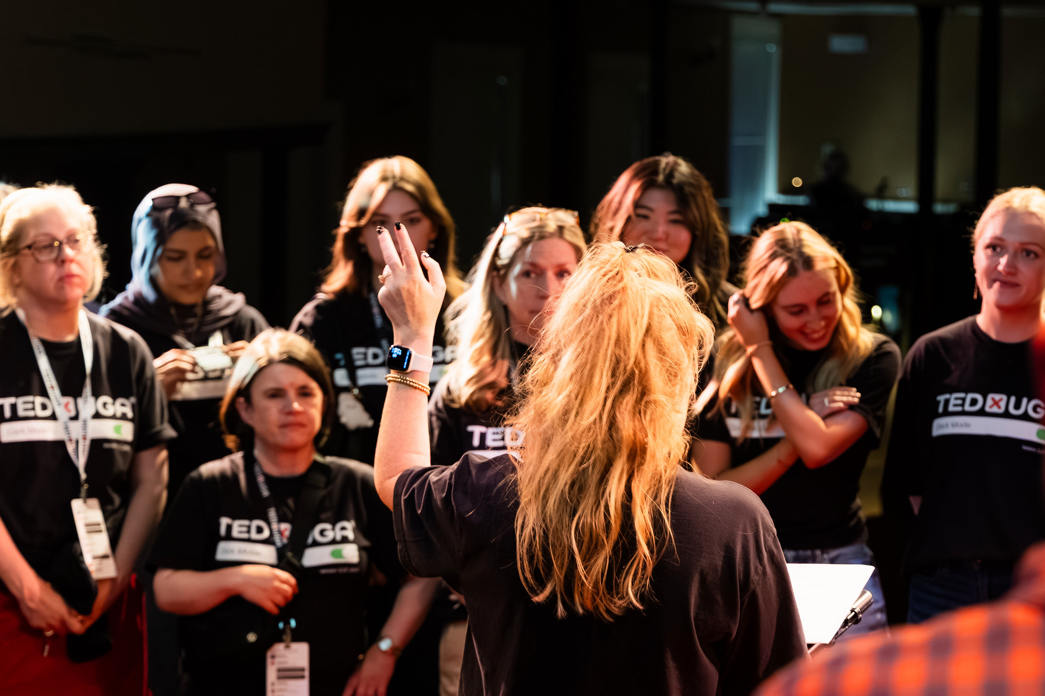 Megan talking to the team on stage at TEDxUGA 2026 Dark Mode